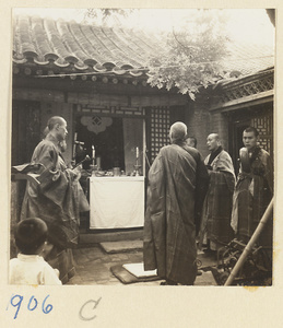 Buddhist monks playing musical instruments at courtyard altar during funeral service