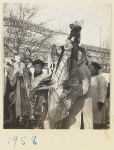 Members of a funeral procession carrying paper figures