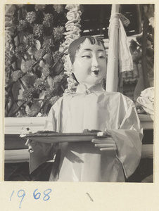 Paper figure of a female servant with a tray in a funeral procession