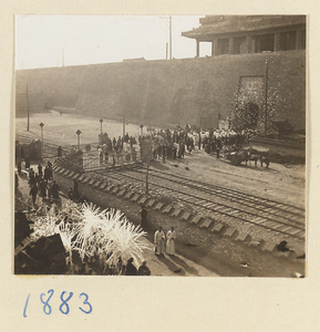 Funeral procession with paper snow willows, mourners dressed in white passing through city gate, and paper money tossed in the air