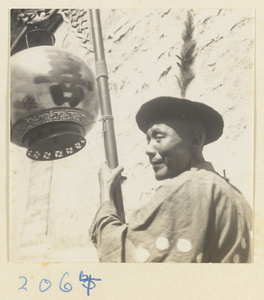 Man carrying a lantern inscribed with characters meaning double happiness in a wedding procession