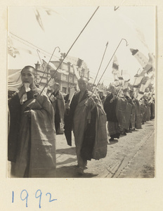 Buddhist monks carrying inscribed Buddha banners in a funeral procession