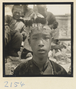 Boy pilgrim wearing a souvenir hat on the trail up Miaofeng Mountain