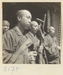 Monks with gong standing at temple entrance on Miaofeng Mountain