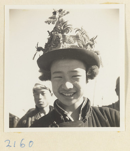 Boy wearing a hat decorated with souvenirs on the pilgrimage trail on Miaofeng Mountain