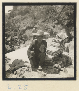 Man with incense for pilgrims along trail up Miaofeng Mountain