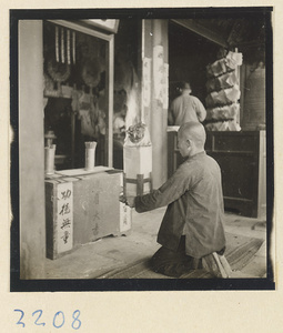 Pilgrim burning a paper offering before an altar on Miaofeng Mountain