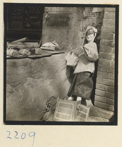 Paper offering figure propped up against a wall next to bundles of incense on Miaofeng Mountain