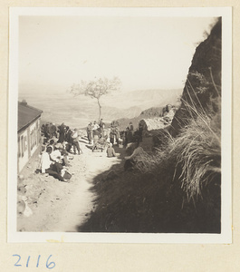 Pilgrims resting next to buildings on trail up Miaofeng Mountain