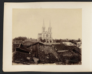 Looking over tiled roofs toward church steeples, Canton