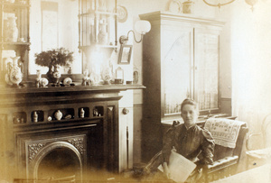 Susan Wilcockson sitting by a fireplace