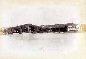 A triple-arched bridge and waterside warehouses