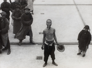 A snake charmer performing on a waterfront