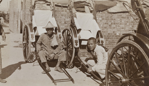 Two rickshaw pullers beside their rickshaws, Hong Kong