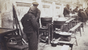 Street food cooks with customers eating at trestle tables, Shanghai