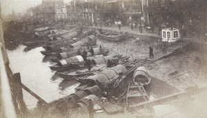 Sampans moored on a creek bed beside a busy street