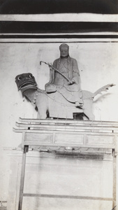 Wooden temple statue of Buddha riding a lion