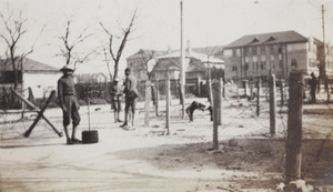 Soldiers by barbed wire entanglements at a road junction, Shanghai