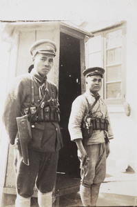Two Chinese soldiers with pistols beside a sentry box