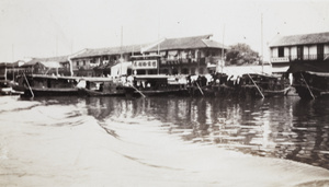 Boats moored by riverside houses