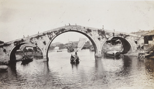 Three arched stone bridge photographed from a boat