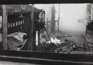 Firefighter in street ablaze with flames and thick with smoke, Shanghai, 1937