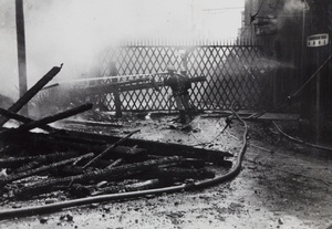 Fire fighters hosing down fires after bombing in Chungshan Road, Shanghai, 1937