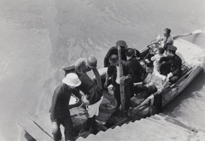 A boat with containers (likely food), a soldier, policemen, and others, by steps, Shanghai, 1937