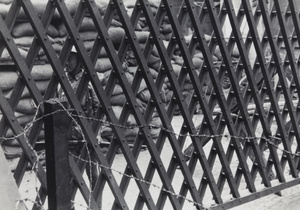 Nationalist soldier between a gate and sandbagged guard post, Shanghai, 1937