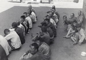 Three rows of men sitting on the ground, Shanghai, 1937