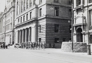 Shanghai Volunteer Corps marching past the Custom House and a guard post on the Bund, Shanghai, 1937