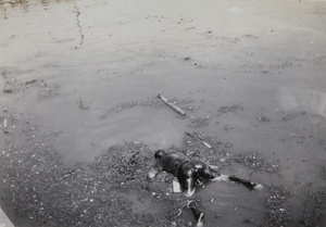 The corpse of a man in Soochow Creek, near Kiangse Road Bridge, August 1937