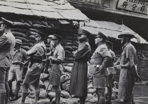 British soldiers and officers watching a Chinese sniper or soldier dubbed 'Charlie Chan II', near the Pantheon Theatre, Shanghai, 1937