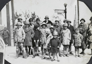 Women and children beside a street sign