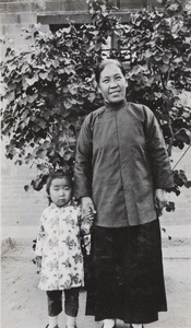 A Woman and a child by a garden plant
