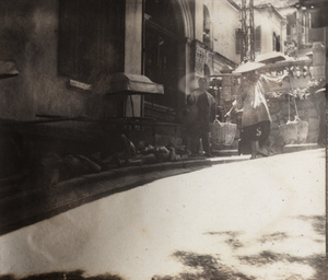 Men resting on a pavement, and a porter, Hong Kong