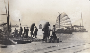 Stevedores unloading sacks, and a tallyman, Hong Kong