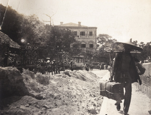 A porter with a suitcase and a funeral procession, Hong Kong