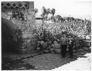 Two boys in uniform, on sentry duty by a gateway, Central Hebei province