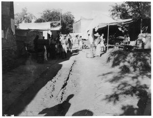 Makeshift stalls at a market beside a rutted road