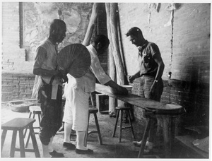 Two Chinese men at a table with George E. Taylor, 1938