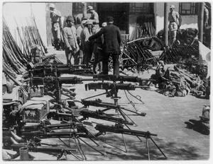 Chinese and Japanese soldiers, with captured weapons, uniforms, documents and a Japanese flag