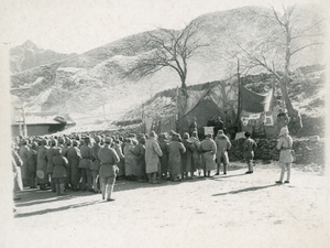 Soldiers at a mass meeting in front of a stage