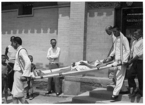 A man on a stretcher with his arm in plaster