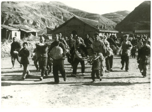 People carrying items, including food, in a village