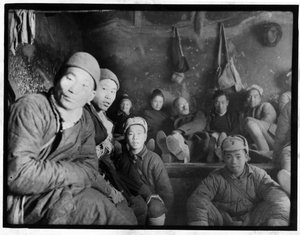 Claire Band, Hsiao Li Lindsay (李效黎) and Michael Lindsay (林迈可) on a kang, with the first Chinese troops they met after their escape from Beijing, December 1941