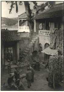 Soldiers in a courtyard of a house near Beijing, with maize hanging up to dry 