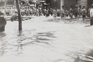 British servicemen wading through a flooded street, Tianjin