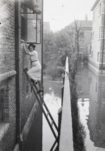 Rachel Morrison on a ladder, Tianjin floods, September 1938