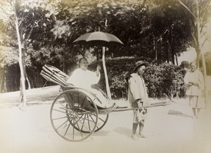 Rickshaw puller, and passenger with umbrella, Peking